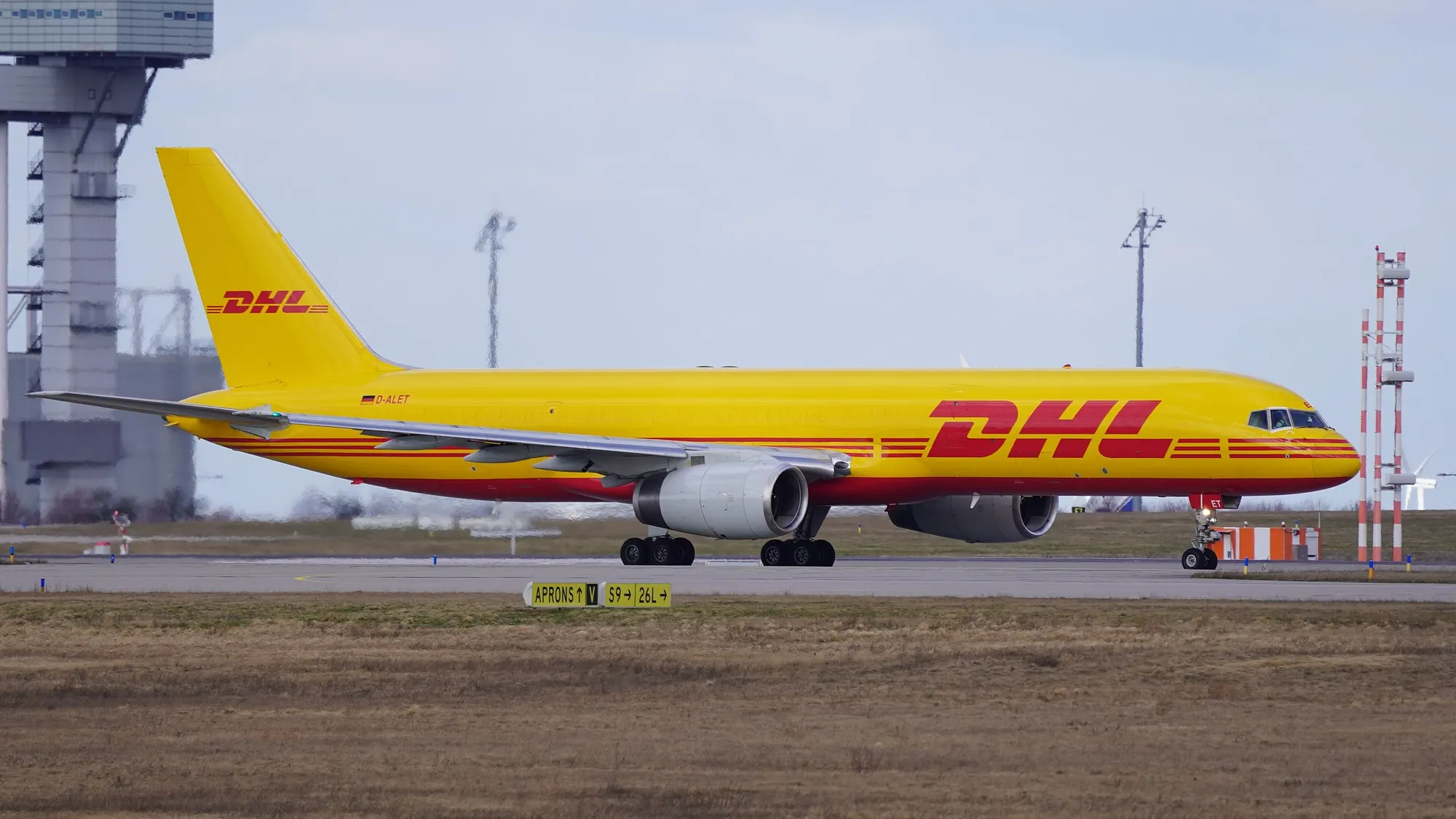 A yellow DHL Boeing 757 freighter operated by European Air Transport Leipzig taxiing at Leipzig/Halle Airport